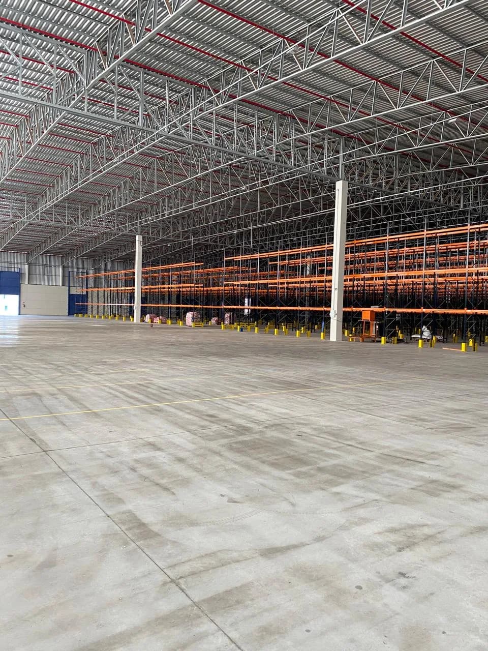 Centro de distribuição implantado, com estruturas porta-pallet novas e área de movimentação livre.