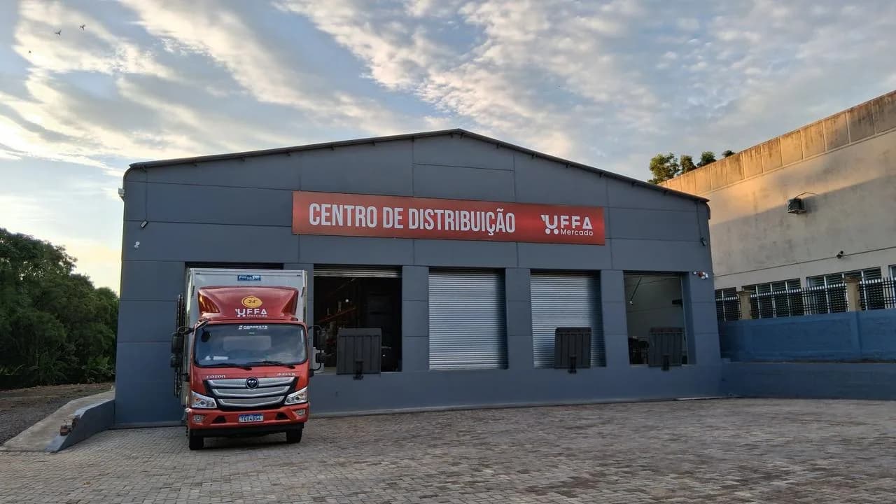 Centro de distribuição da UFFA pronto, com caminhão da rede carregando na doca.